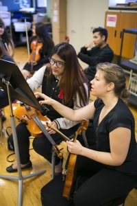 Civic Orchestra members work with Schurz High School musicians before a side-by-side performance.