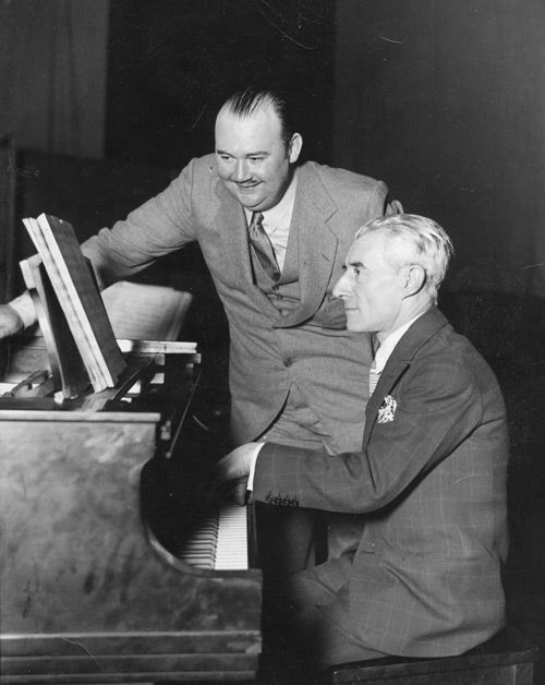 Paul Whiteman (standing) and Maurice Ravel in 1928.